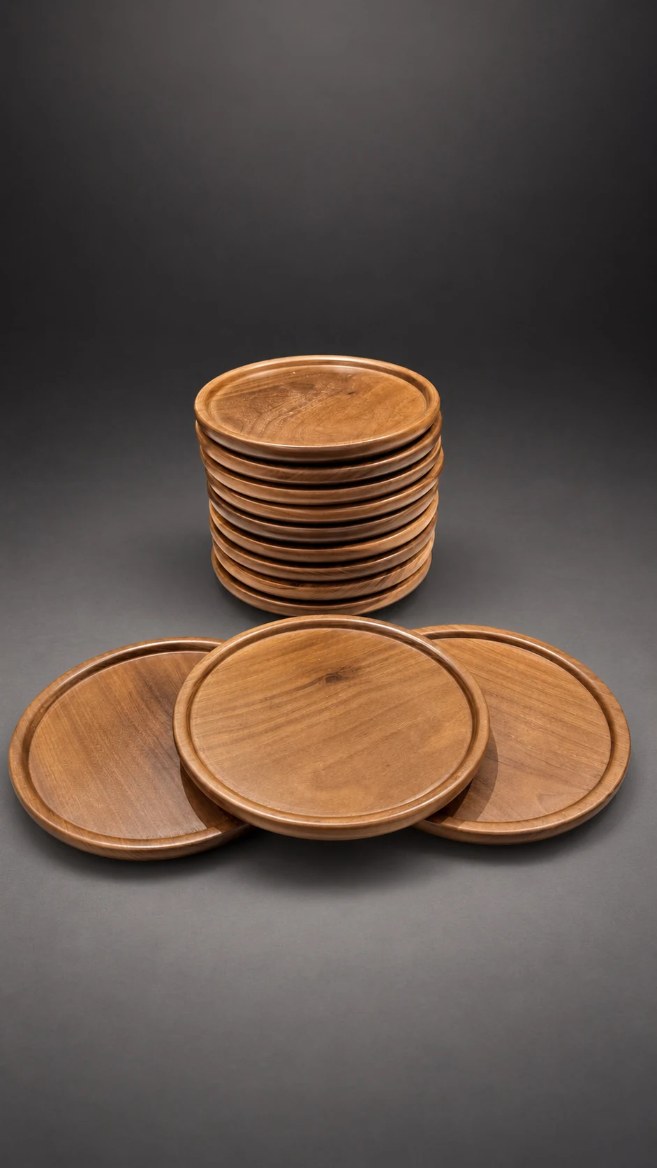 Platos playos de madera apilados, con tres apoyados adelante donde se ve la veta y el borde bajo