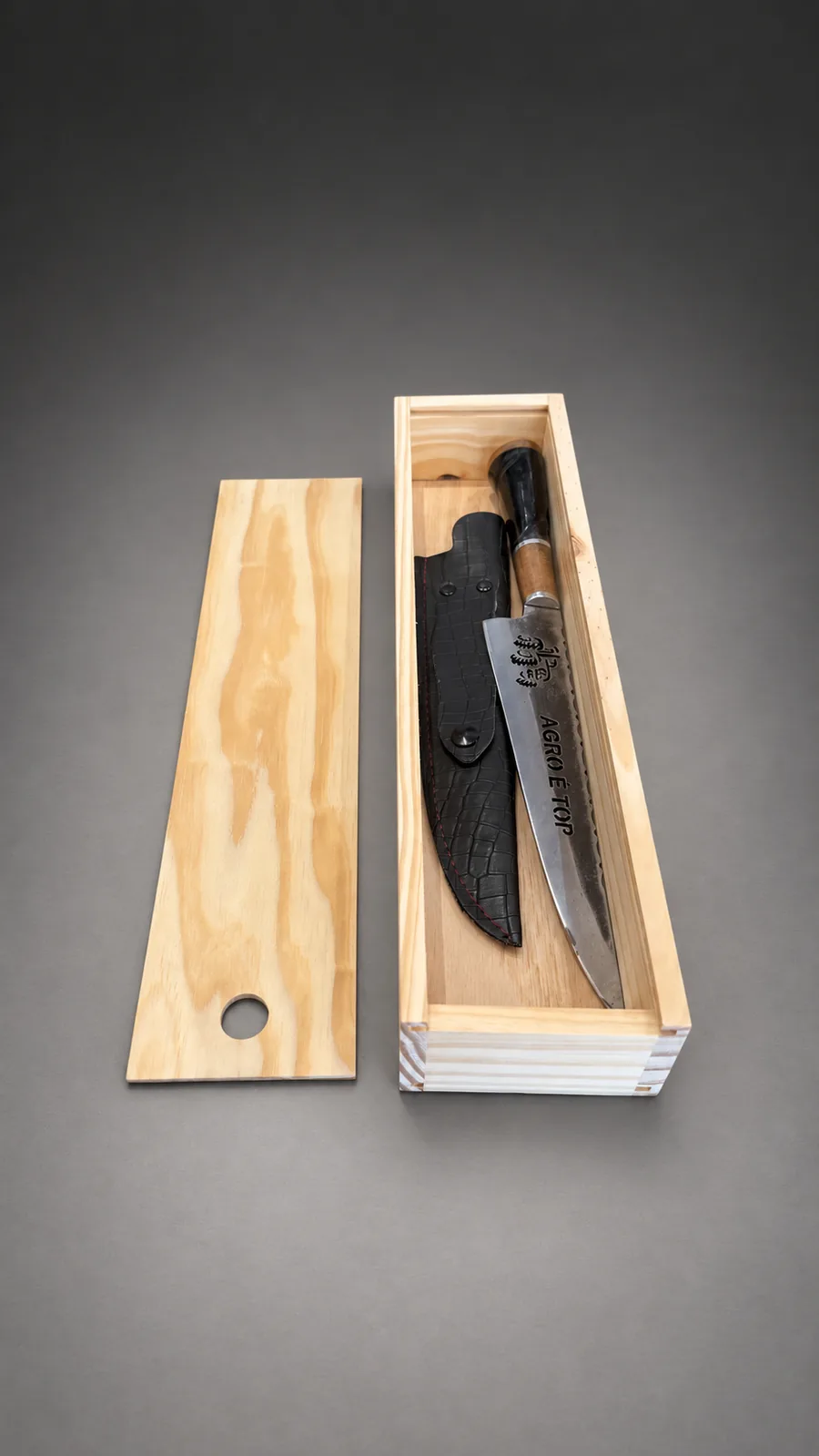 Cuchillo artesanal con su vaina de cuero dentro de la caja de pino, con la tapa corrediza al lado