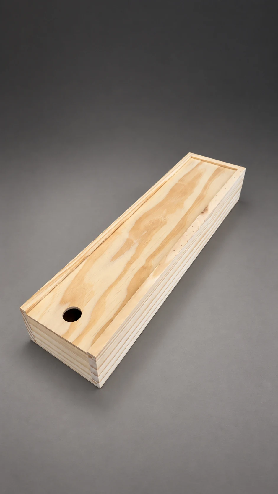 La caja de pino del cuchillo cerrada, con la tapa corrediza y el agujero para abrirla